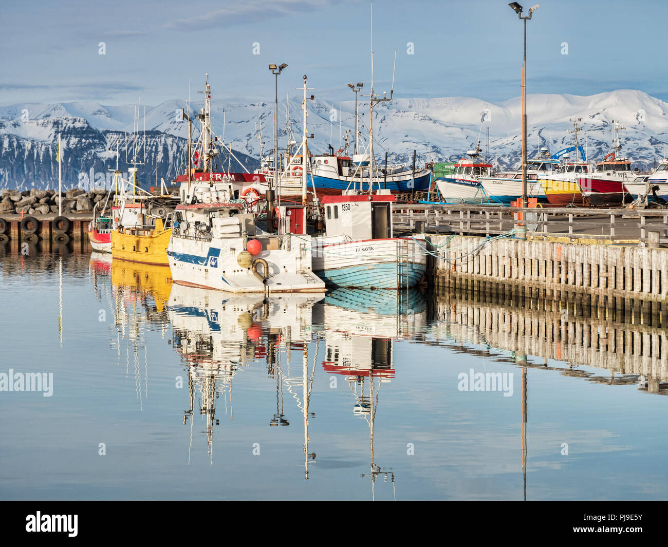 13 April 2018: Husavik, North Iceland - Fishing boats in the harbour on a bright spring day. Stock Photo