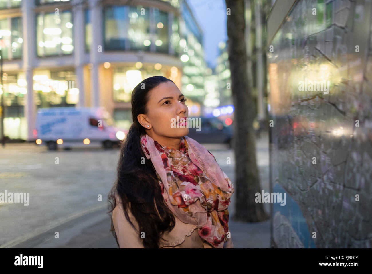 Businesswoman looking at city map on urban street at night Stock Photo