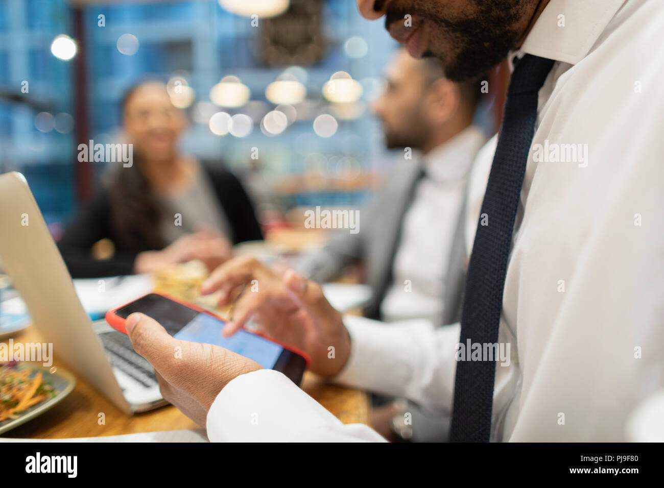 Close up businessman using smart phone in cafe Stock Photo