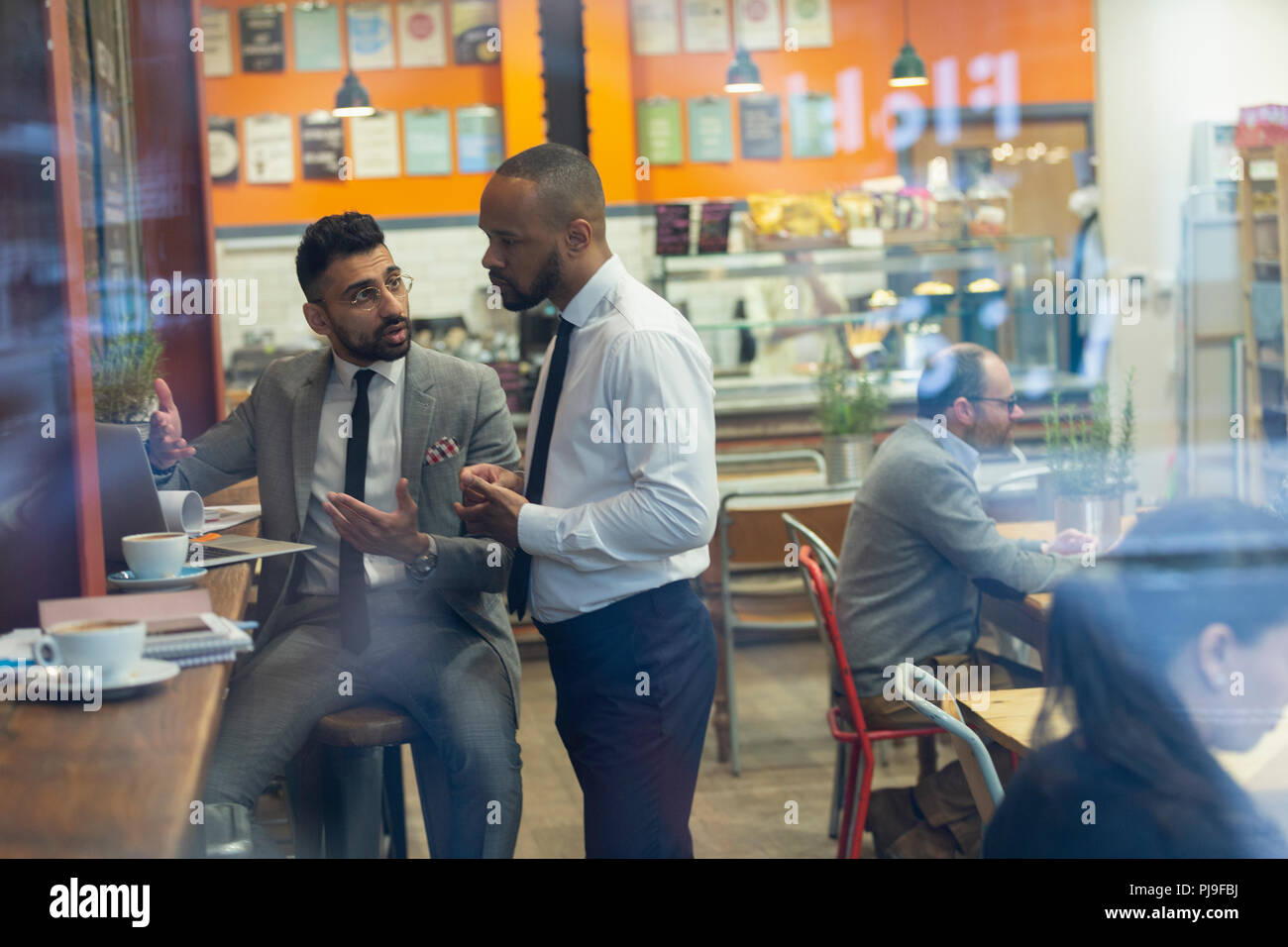 Businessmen using laptop, working in cafe Stock Photo
