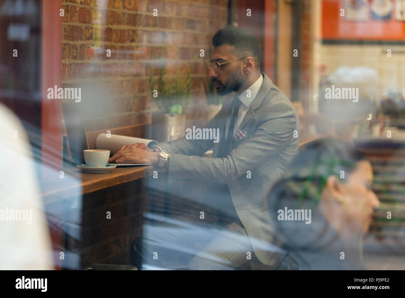Businessman working at laptop in cafe Stock Photo