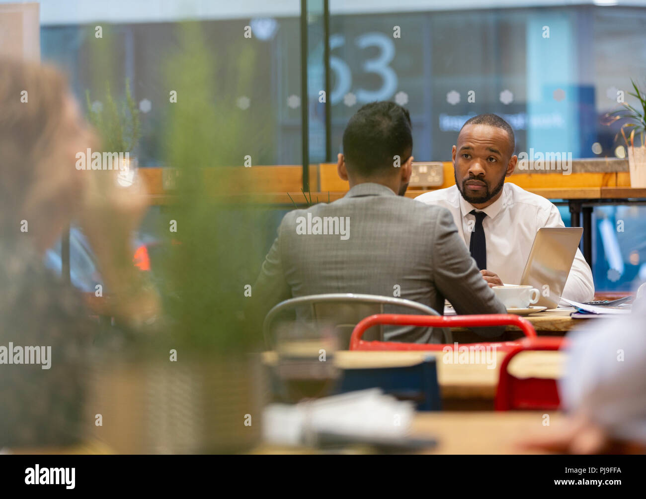 Businessmen talking, working in cafe Stock Photo