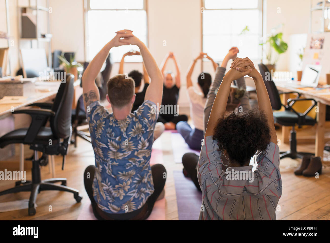 Creative business people practicing yoga in office Stock Photo - Alamy