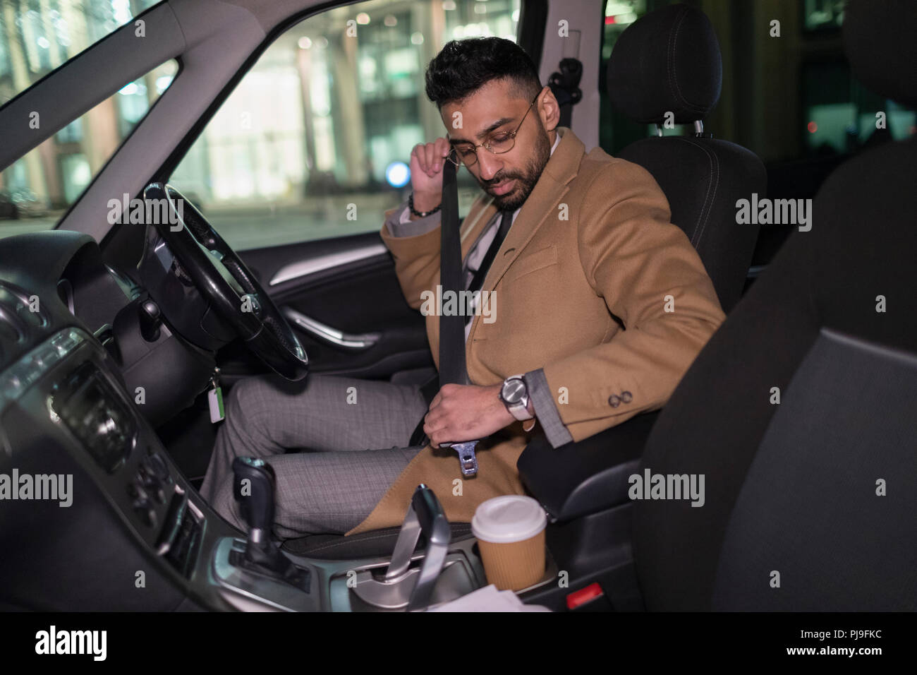 Businessman buckling seat belt in car Stock Photo