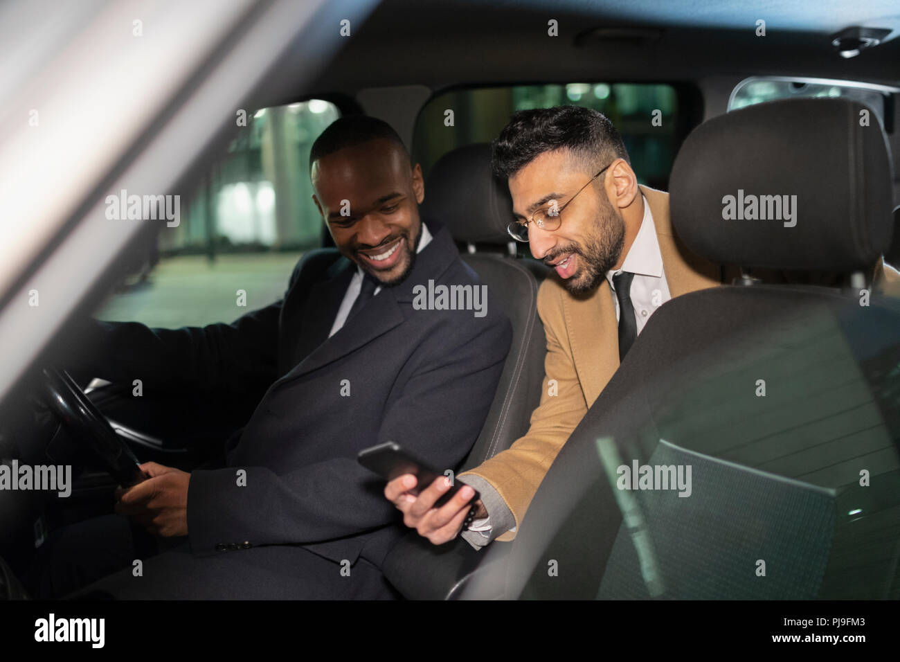 Businessman with smart phone using crowdsourced taxi Stock Photo