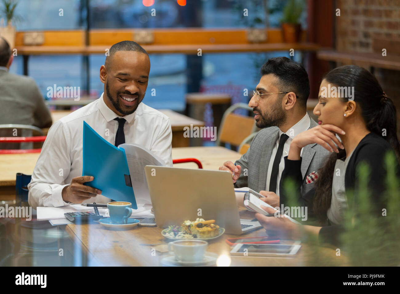 Business people discussing paperwork, working in cafe Stock Photo