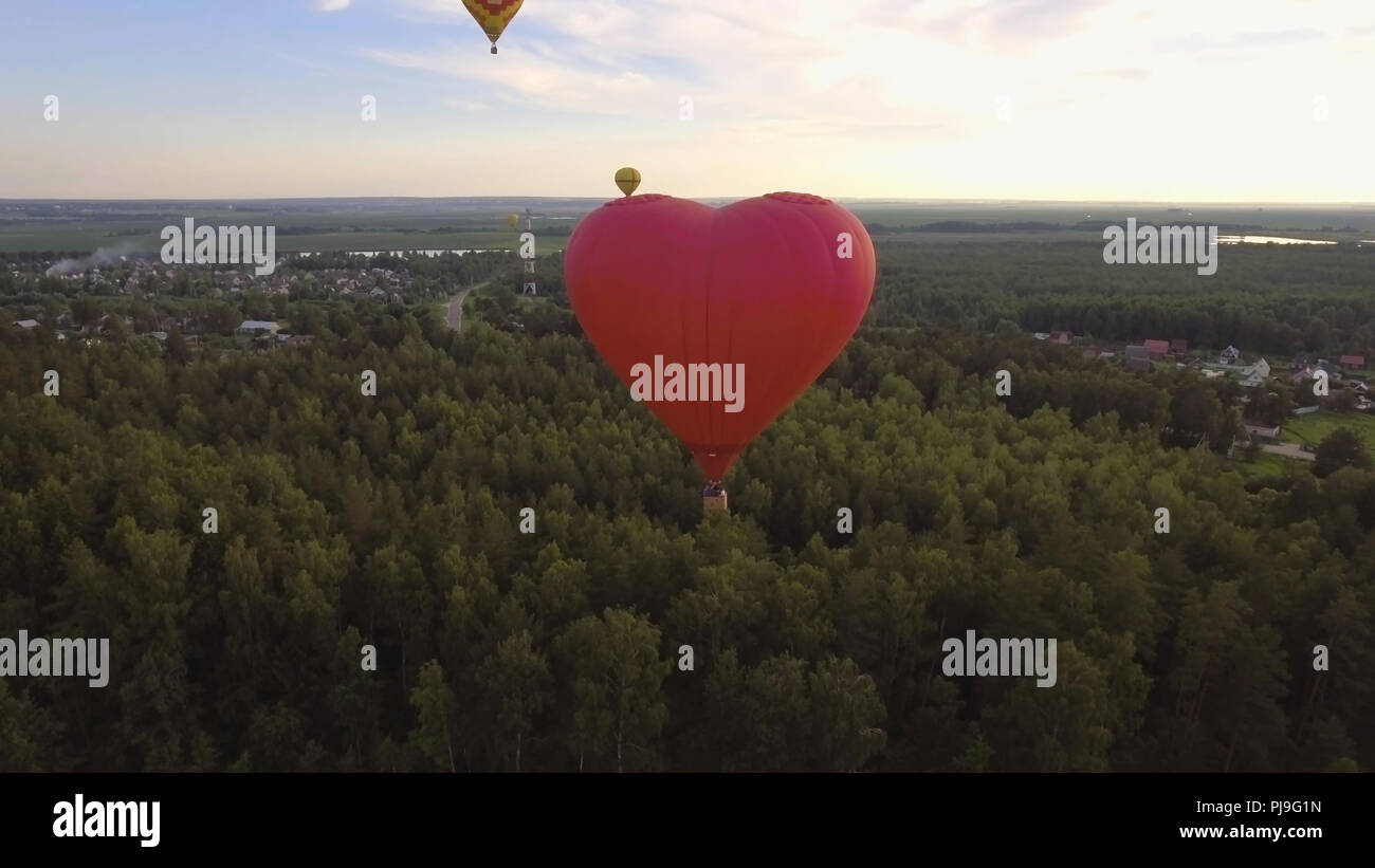 Hot air balloon shape of a heart in the blue sky. Aerostat, Airship ...