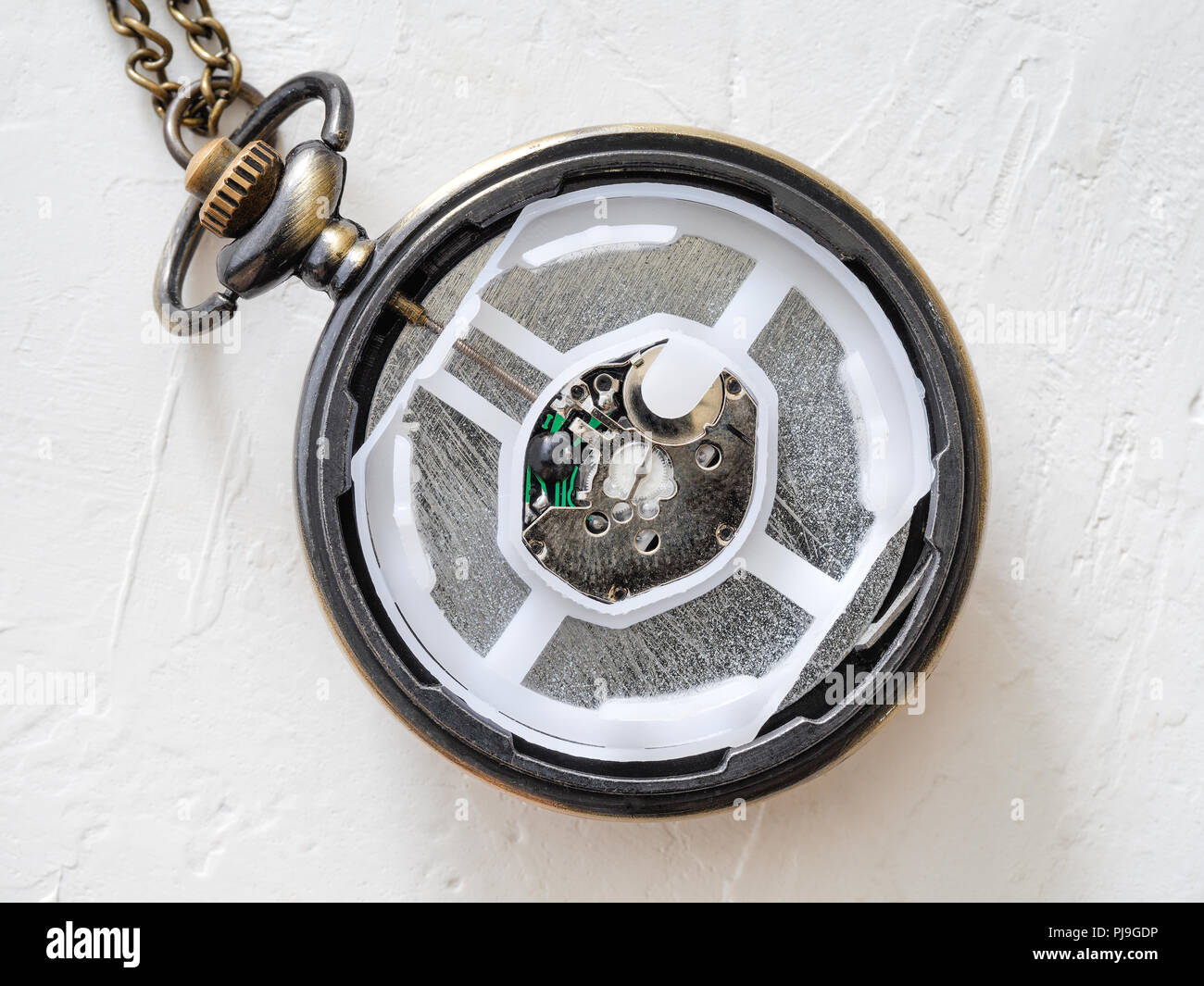 open retro style pocket watch with little modern quartz movement on
