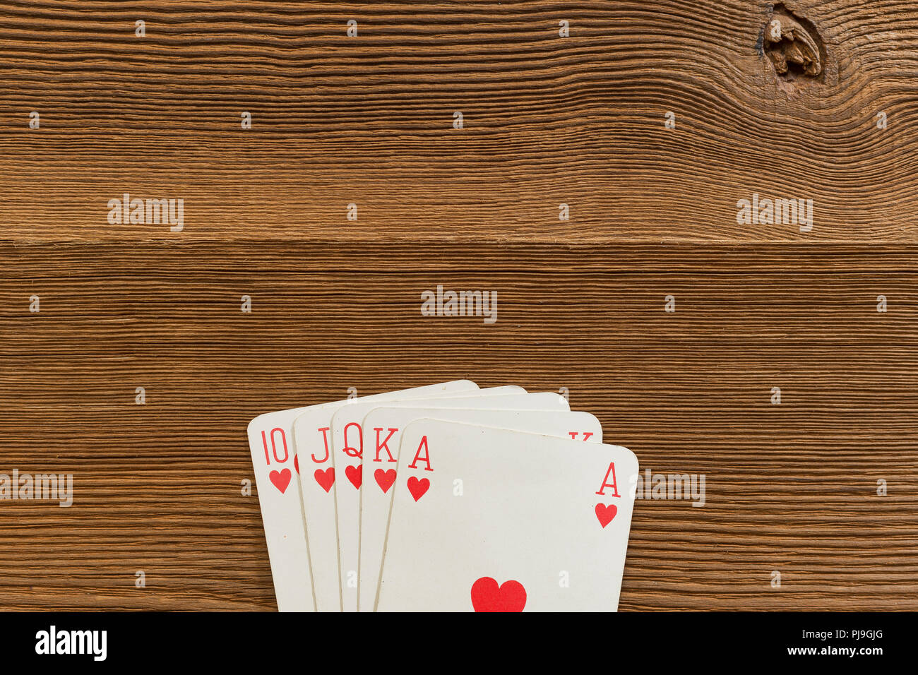 Poker cards royal flush the highest ranking hand in holdem poker on wooden backdrop textspace Stock Photo