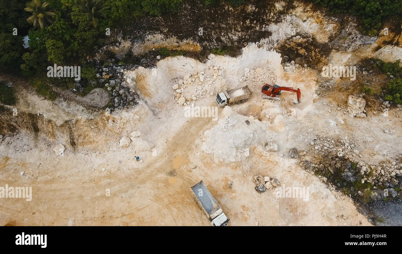 Excavator loads the truck in a limestone quarry. Aerial view wheel