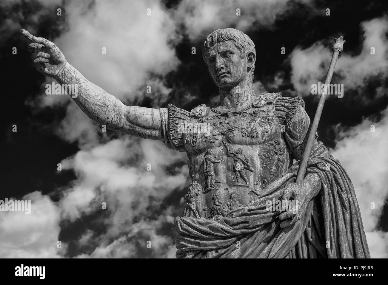 Caesar Augustus, the first emperor of Ancient Rome. Bronze monumental statue in the center of Rome, with clouds (Black and White) Stock Photo