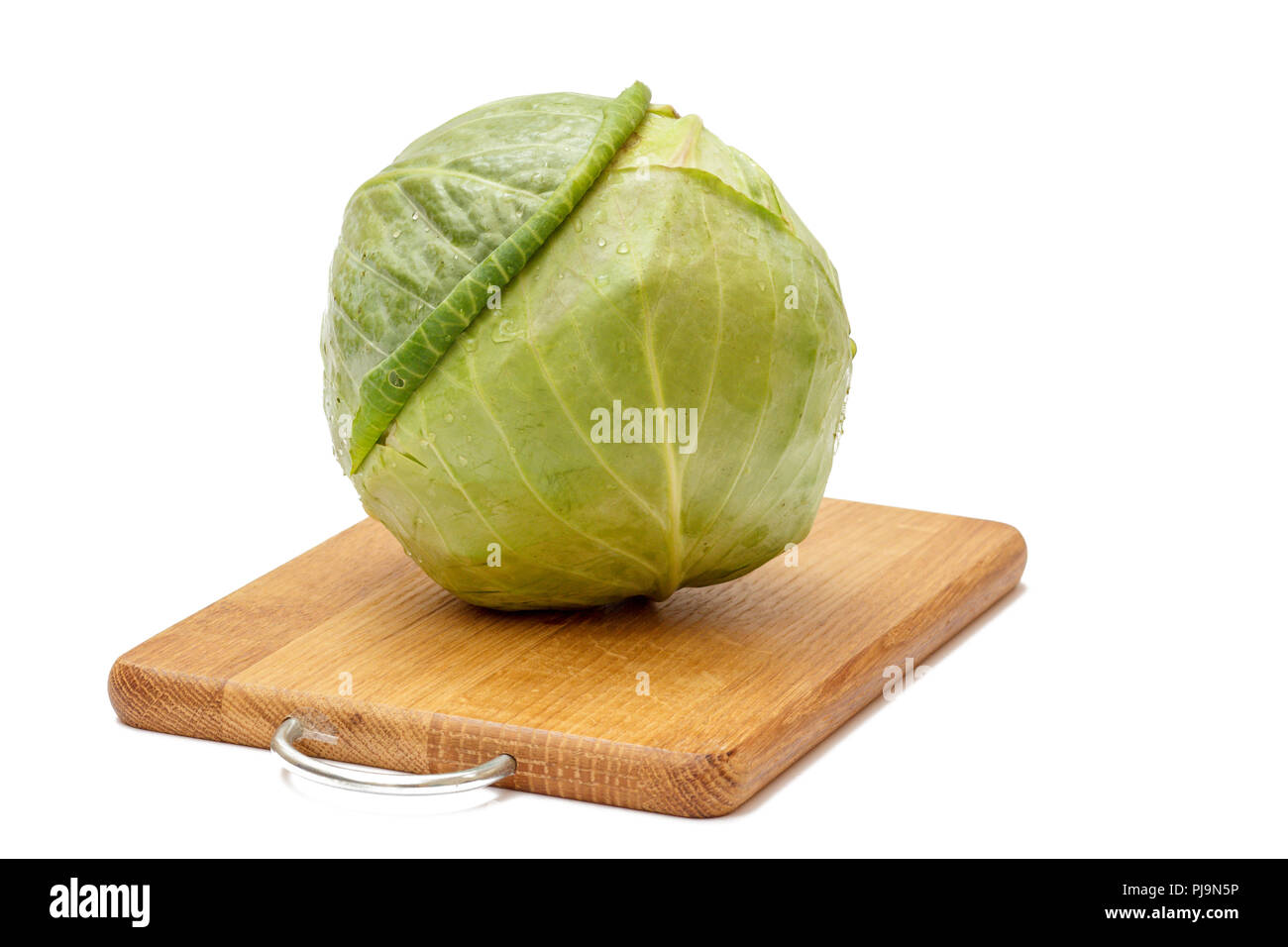 Green cabbage head on wooden cutting board with white isolated ...