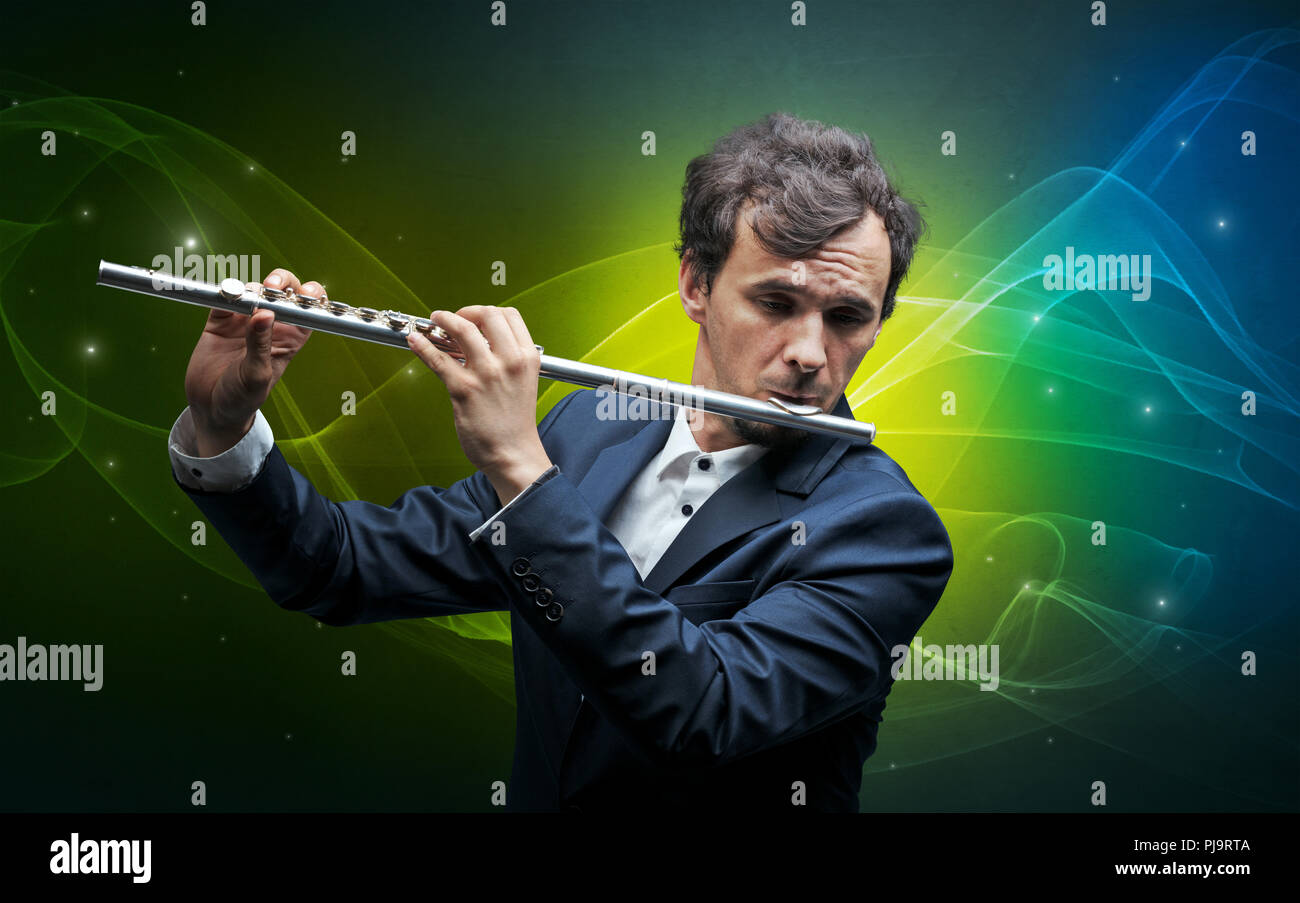 Serious classical flutist with fabled sparkling wallpaper Stock Photo