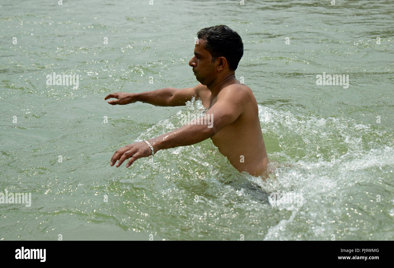 Young man Walking in water Stock Photo