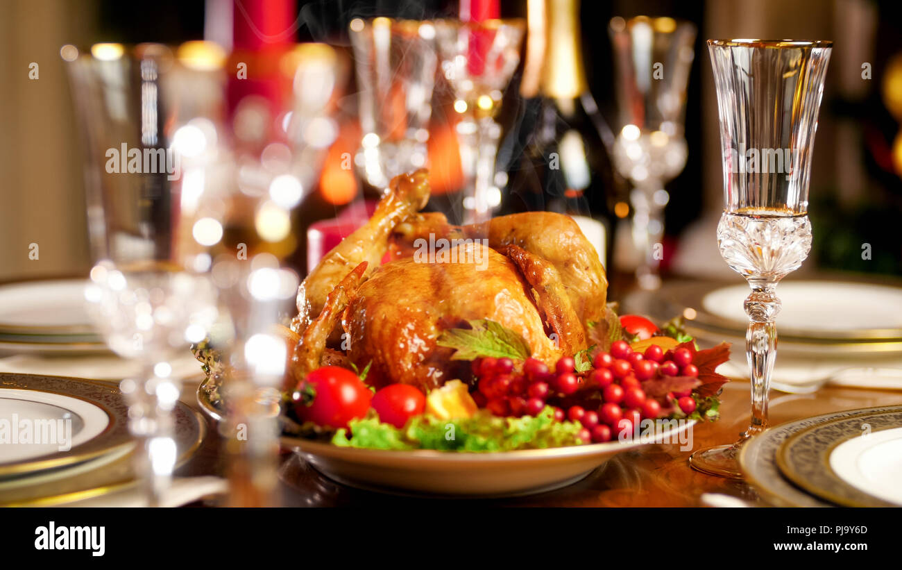 Closeup image of glasses, champagne and baked hot chicken on festive dinner Stock Photo
