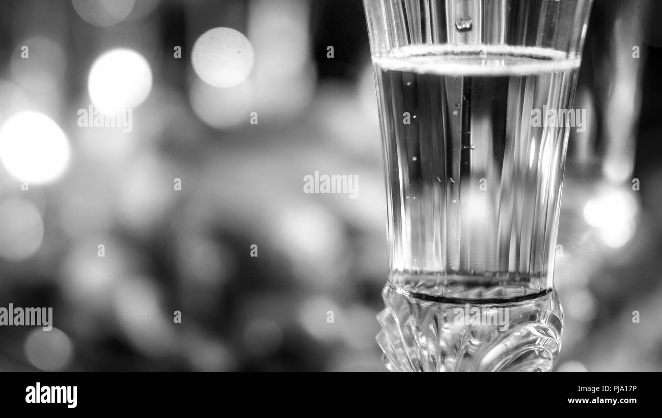Black and white image of air bubble in glass of champagne on dining table Stock Photo