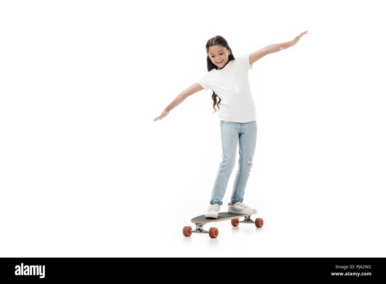 cheerful kid with outstretched arms skating skateboard isolated on white Stock Photo