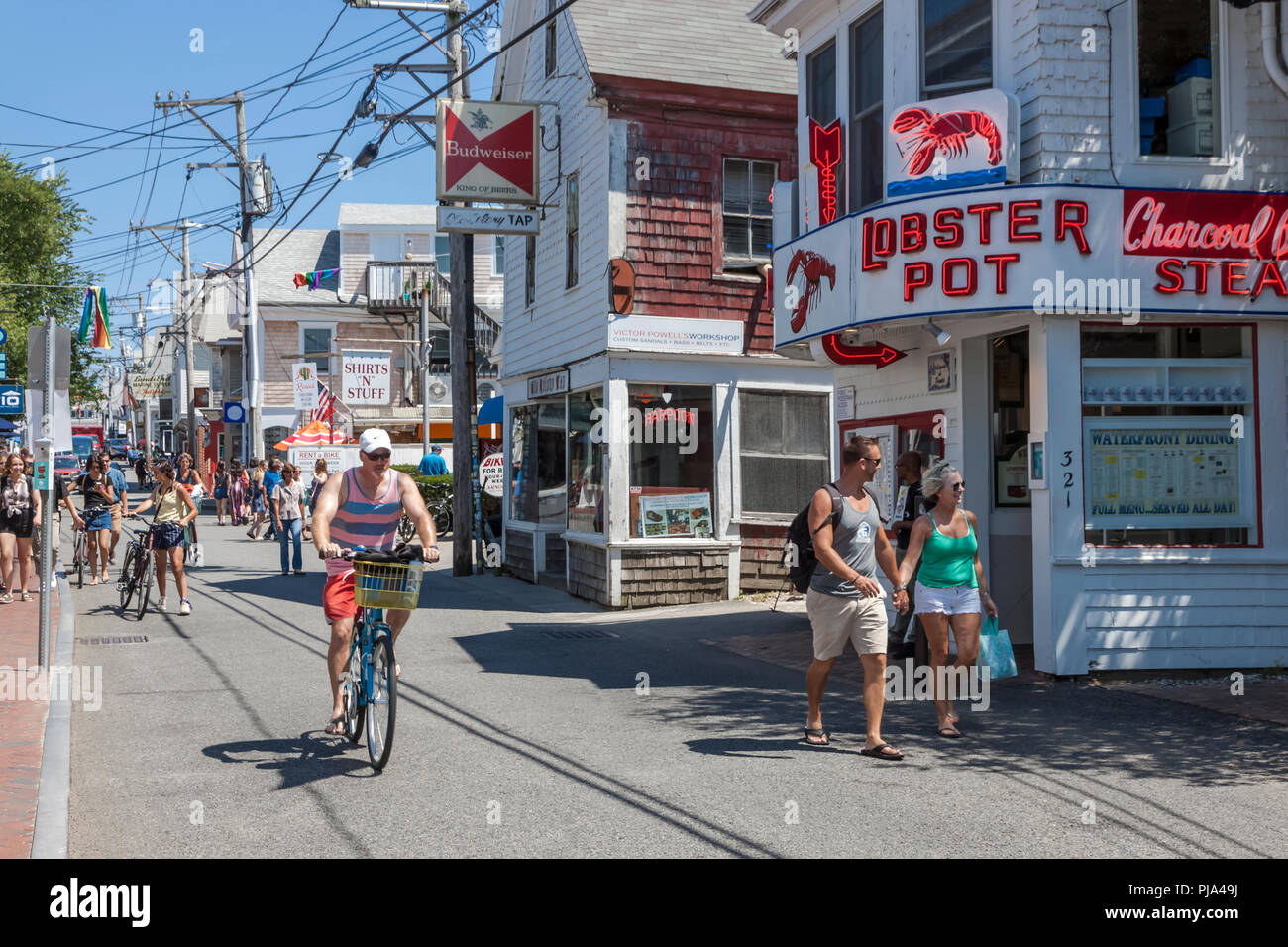 People walking and biking on Commercial Street in Provincetown, Massachusetts, Cape Cod, USA. Stock Photo
