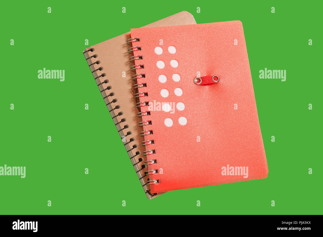 two spiral notebooks on a green surface Stock Photo