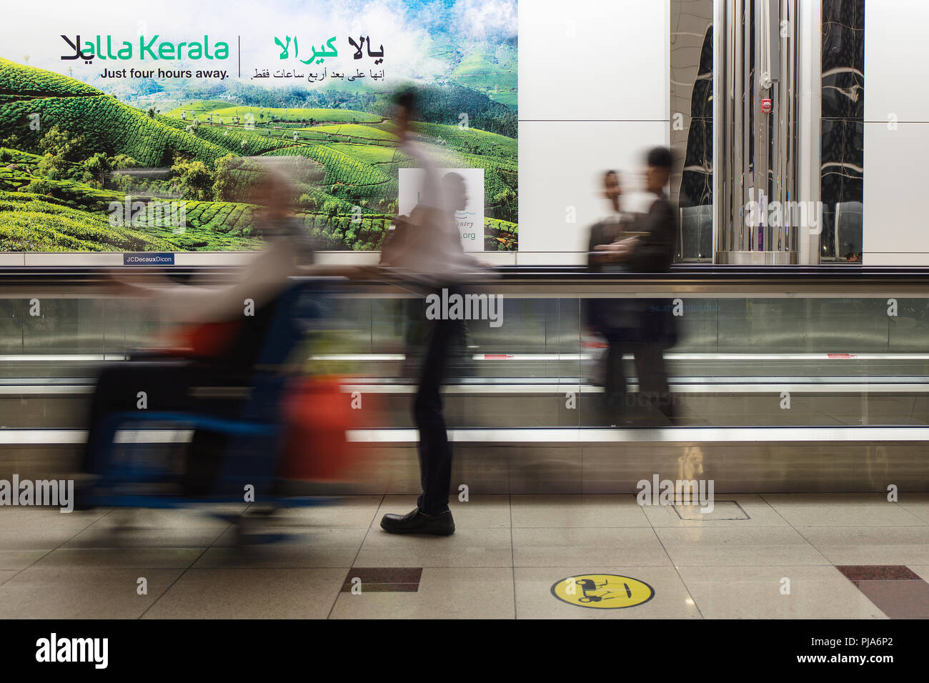 An airport employee assists a person on a wheelchair inside the Dubai