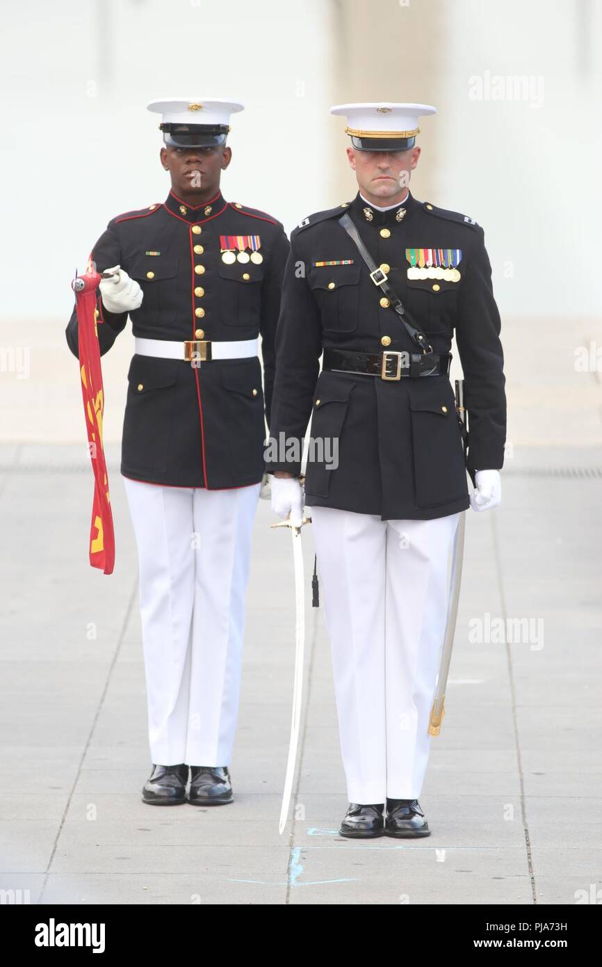 Captain Billy R. Grissom, company commander, Alpha Company, Marine Barracks Washington D.C., and Lance Cpl. Joshua Lawson, guidon bearer, Alpha Company, MBW, render honors during the playing of the National Anthem during a Tuesday Sunset Parade at the Lincoln Memorial, Washington, D.C., July 3, 2018. The guest of honor for the parade was Vice Adm. Walter E. “Ted” Carter, 62nd superintendent of the U.S. Naval Academy, and the hosting official was Lt. Gen. Robert S. Walsh, commanding general, Marine Corps Combat Development Command, and deputy commandant, Combat Development and Integration. Stock Photo