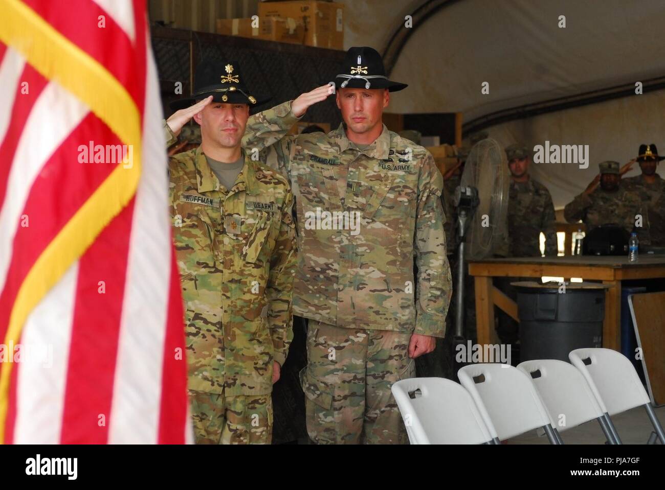 ERBIL, Iraq – U.S. Army 7th Squadron, 17th Cavalry Regiment Operations Officer Maj. Ty Huffman (left) and Standardization Officer Chief Warrant Officer 5 Steve Crandall render a salute while the National Anthem plays prior to a transfer of authority ceremony July 2, 2018. The ceremony signified the assumption of command of the mission to provide enabling support to Coalition and partner forces in the defeat-ISIS mission in support of Operation Inherent Resolve. Stock Photo