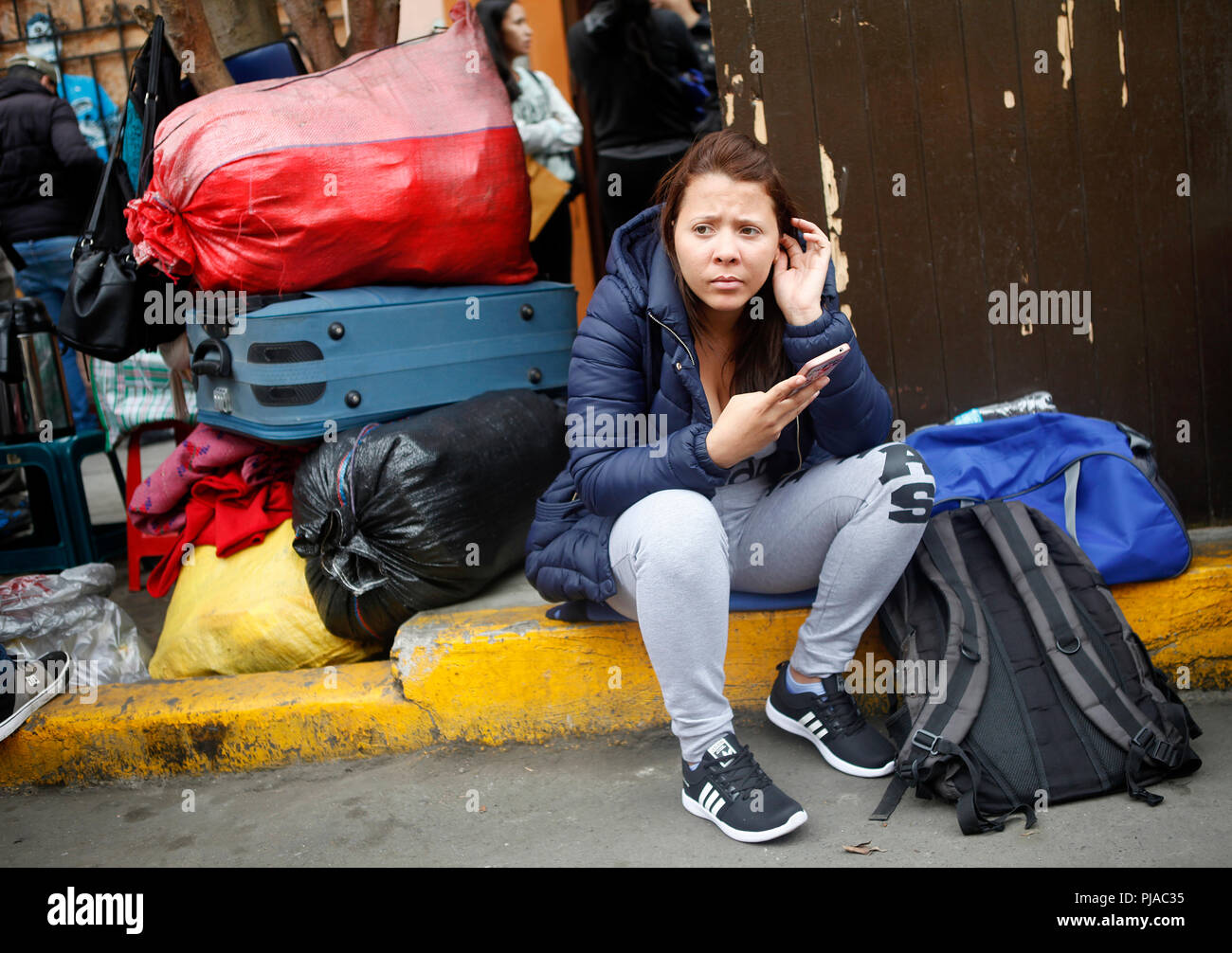 Lima, Peru. 05th Sep, 2018. A woman from Venezuela sits next to