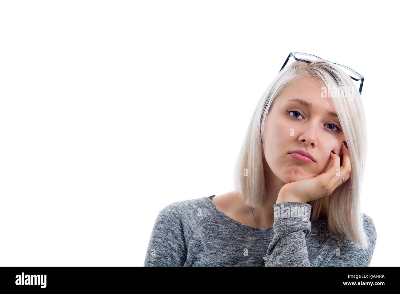 Portrait Of Bored Annoyed Beautiful Girl With Straight Blonde Hair Looking At Camera With Blue