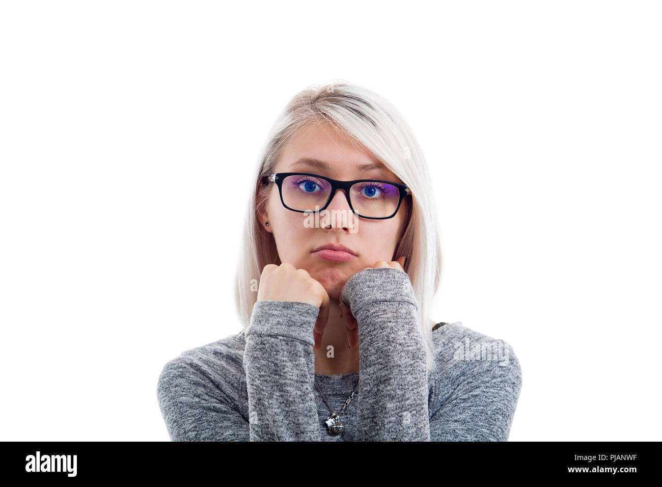 Bored woman wear glasses with both hands under chin looking to camera isolaed on white background. Sad human emotion, tired feeling. Unhappy expressio Stock Photo