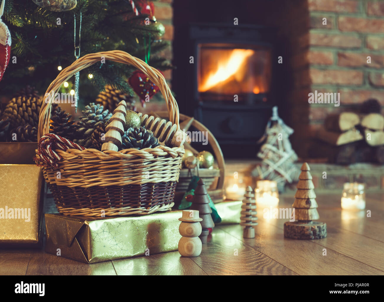 Christmas decorations in the basket in front of fireplace with roaring
