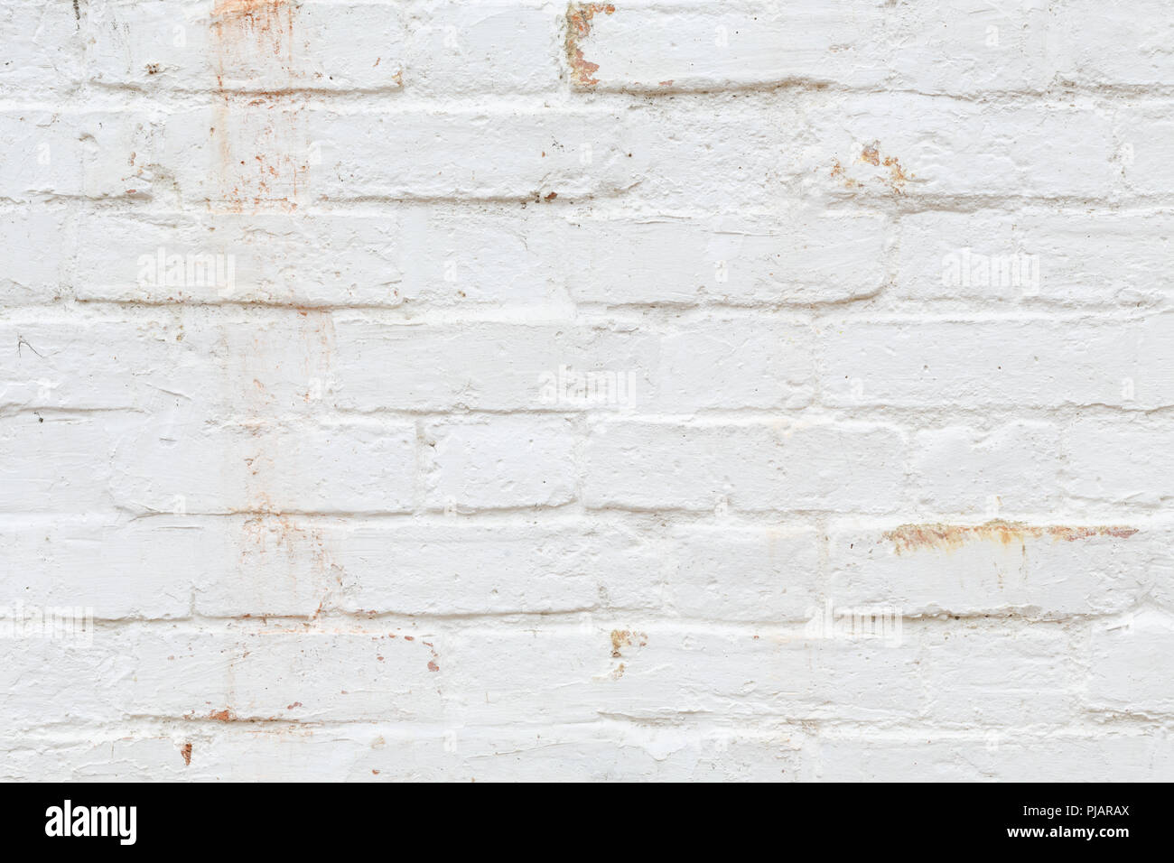 Closeup of old brick wall painted white and distressed, peeling and stained. Ideal for grunge background texture Stock Photo