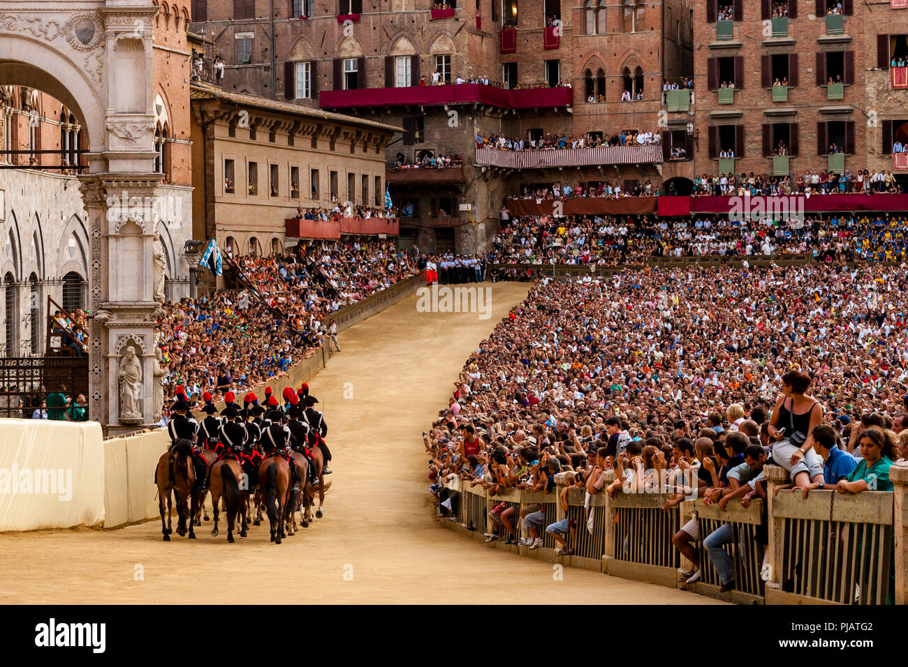 The Mounted Section Of The Italian Carabinieri (Police Force) Prepare To Race Around The Track Before The Start Of The Palio di Siena, Siena, Italy Stock Photo