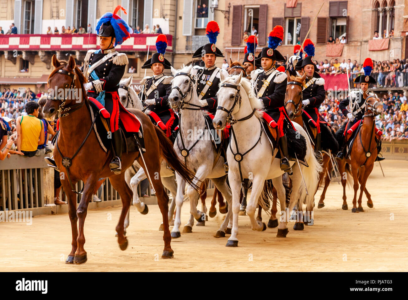 The Mounted Section Of The Italian Carabinieri (Police Force) Prepare To Race Around The Track Before The Start Of The Palio di Siena, Siena, Italy Stock Photo