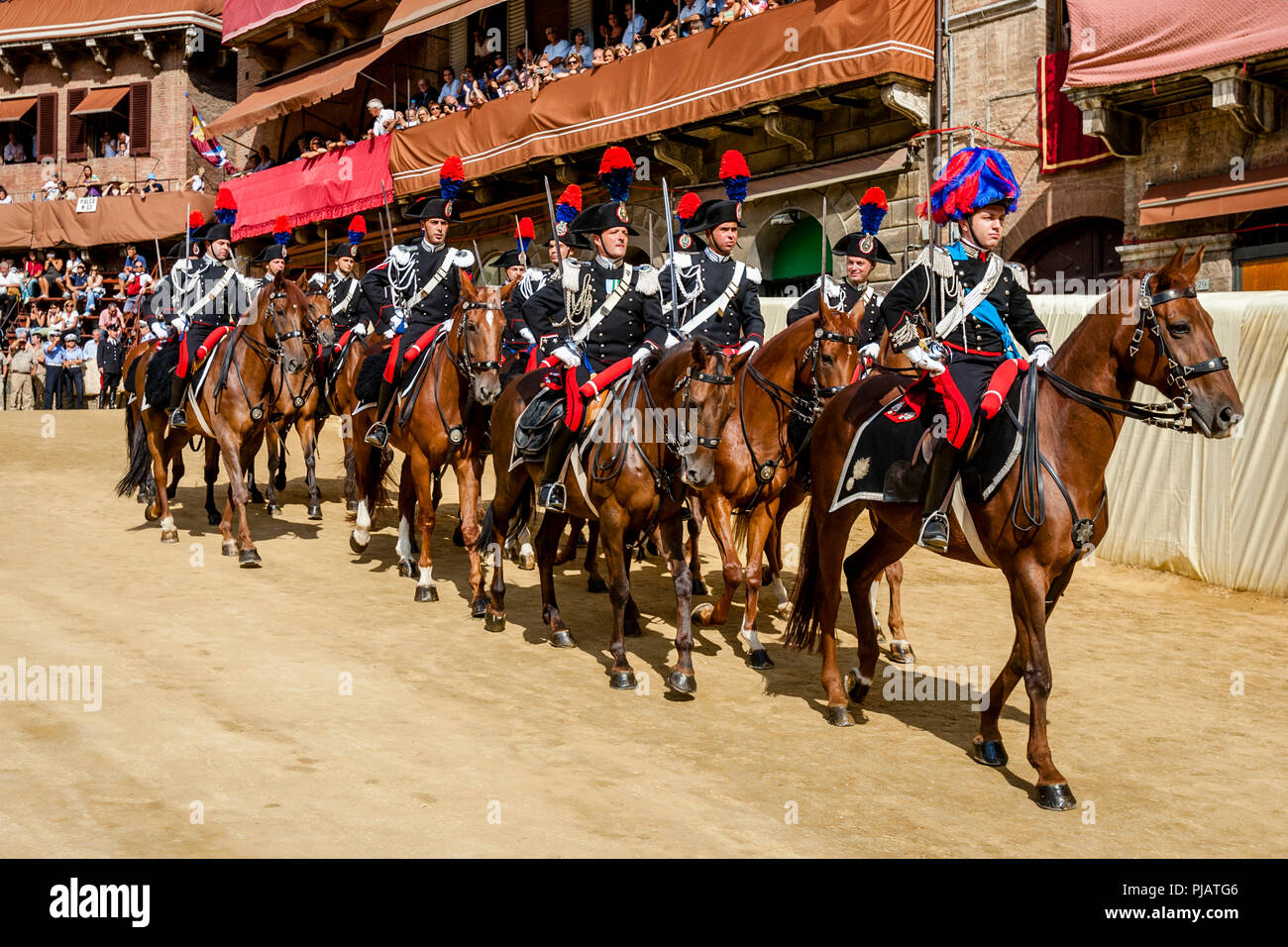 The Mounted Section Of The Italian Carabinieri (Police Force) Prepare To Race Around The Track Before The Start Of The Palio di Siena, Siena, Italy Stock Photo