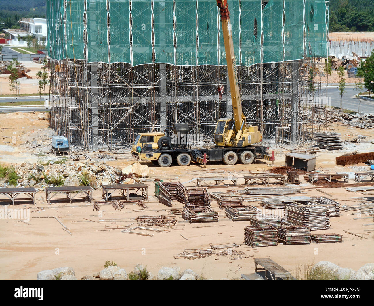 Construction site on progress at site. The construction of the building structure is still in its early stages. Earthwork work is also being done. Stock Photo