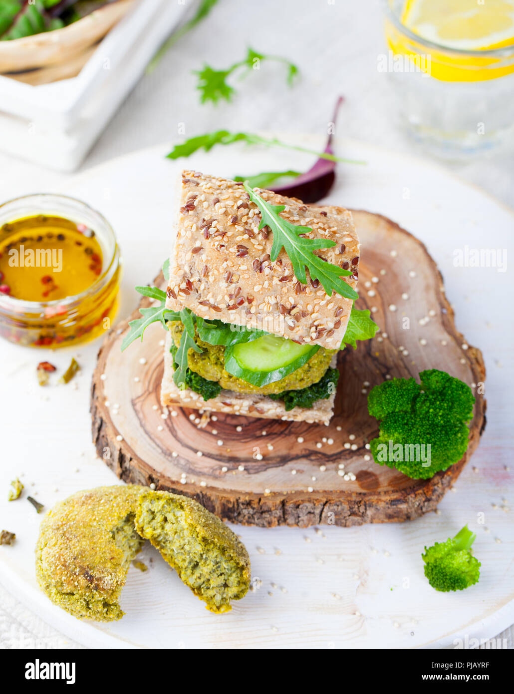 Healthy vegan burger with broccoli and spinach patty on a cutting wooden board. Stock Photo