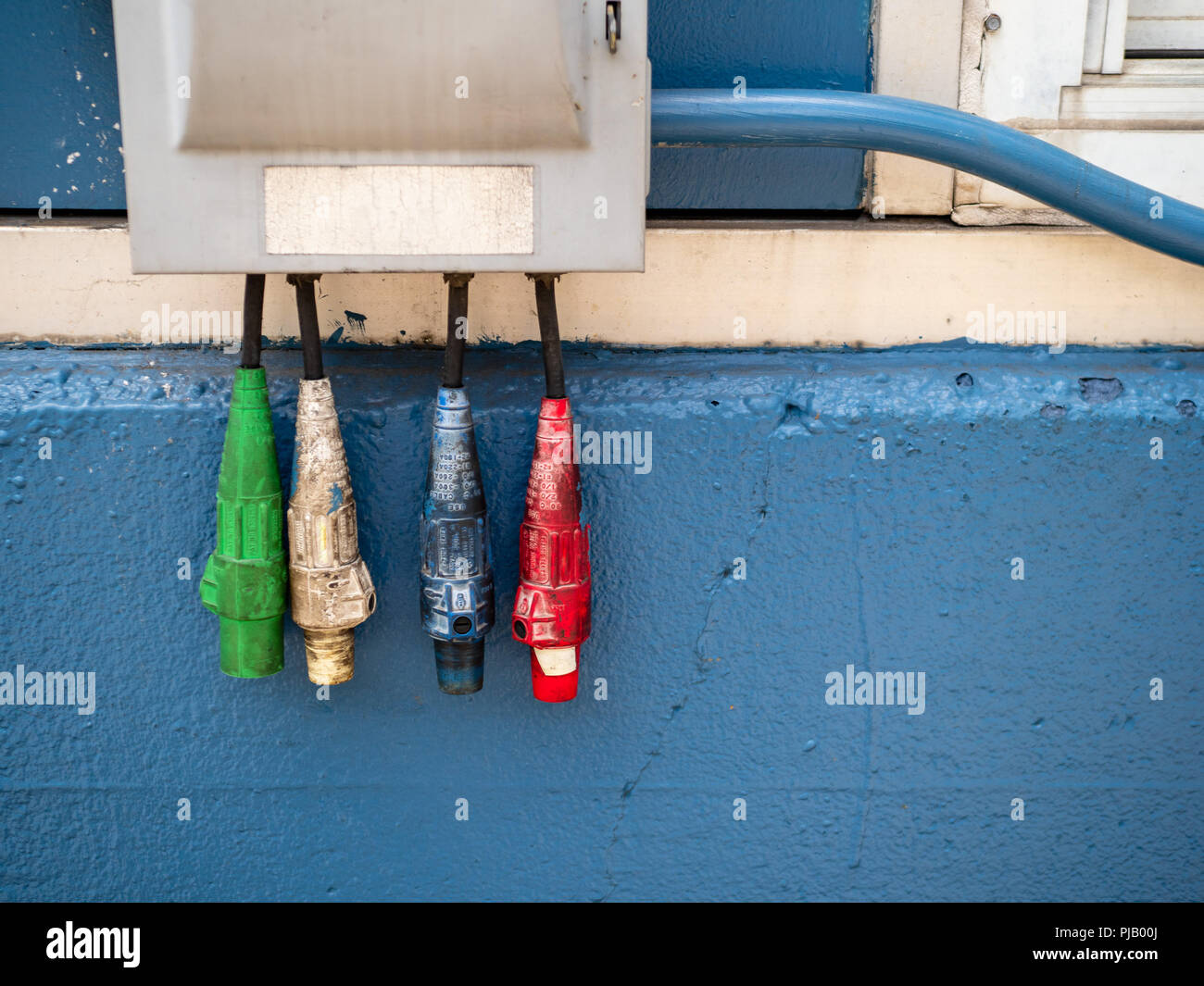 Red, white, blue, and red industrial power cables suspended Stock Photo
