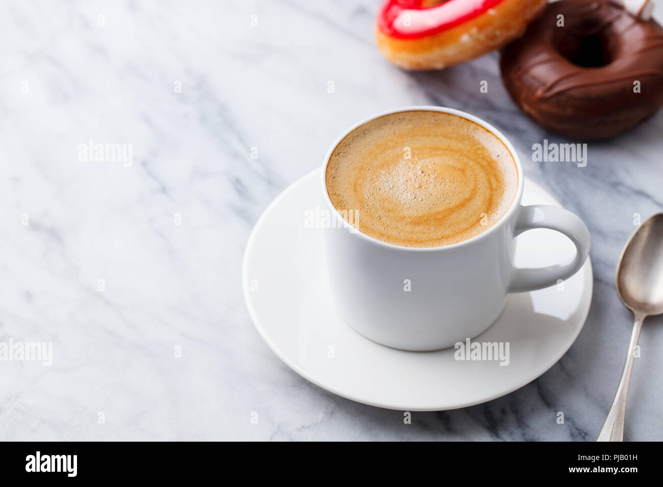 Cup coffee with donuts in marble table background. Copy space. Stock Photo
