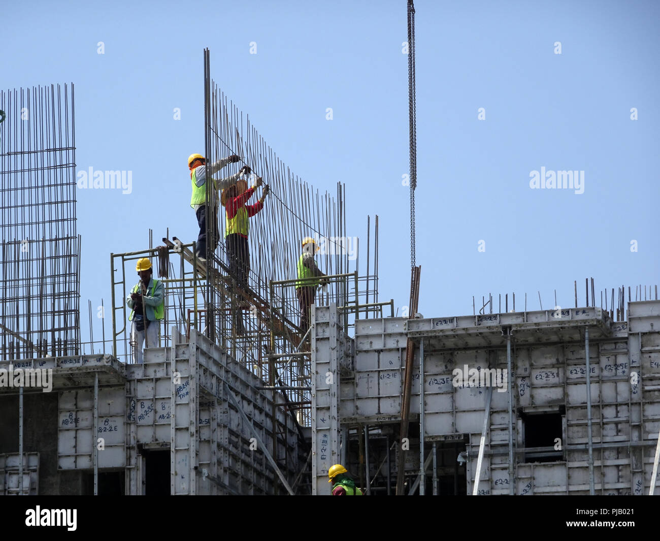 Construction workers installing reinforcement bar at the construction site. Reinforcement bar is the main component for the reinforcement concrete. Stock Photo