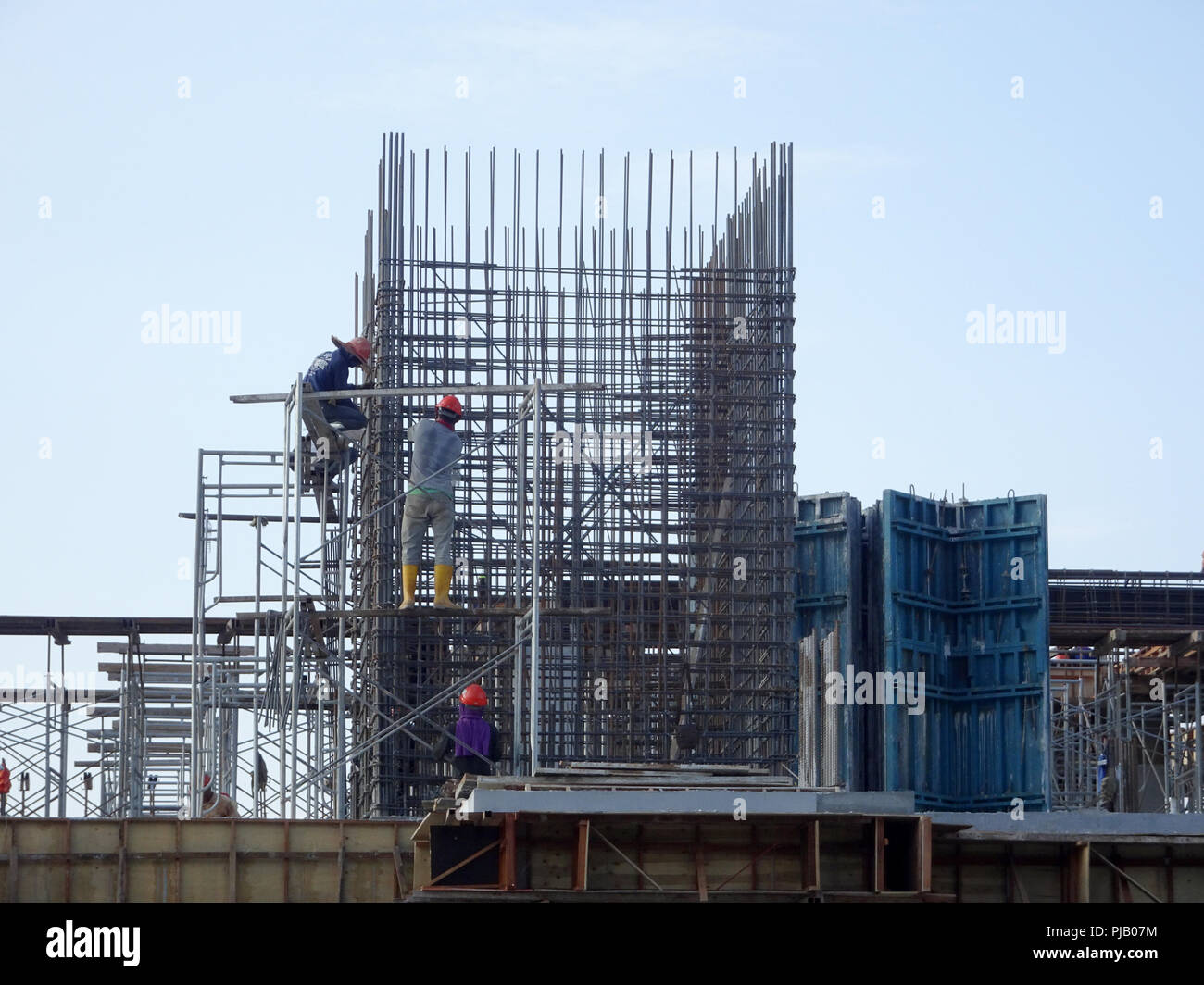 Construction workers installing reinforcement bar at the construction site. Reinforcement bar is the main component for the reinforcement concrete. Stock Photo