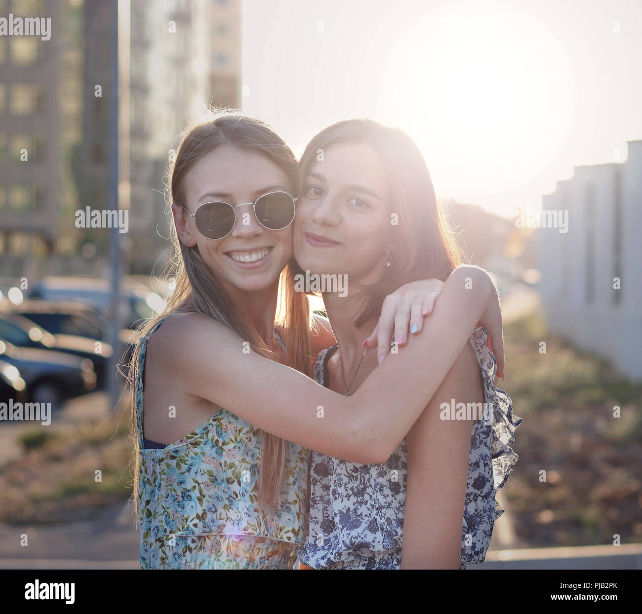 two cute girls holding each other in the evening sun Stock Photo Alamy
