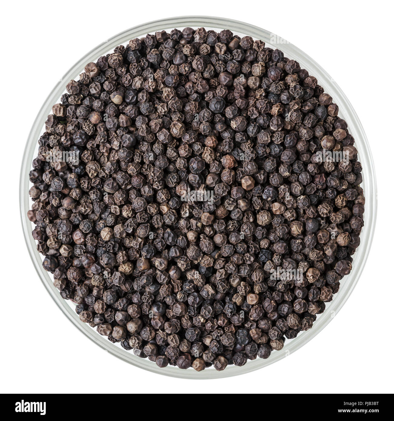Black pepper corns in glass bowl isolated on white background with clipping path Stock Photo
