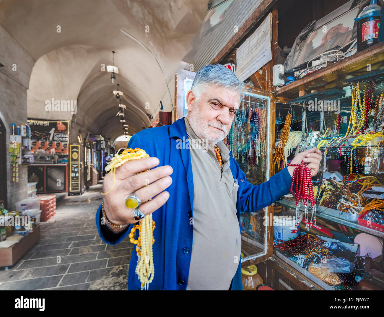 Unidentified man sells different kind of rosaries in old bazaar,Sanliurfa,Turkey.19 July 2018 Stock Photo