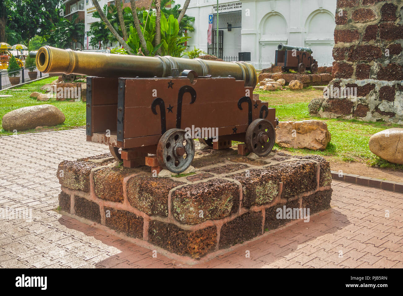 An old large Portuguese bronze cannon on a red sandstone platform at A Famosa, a former Portuguese fortress located in Malacca, Malaysia. Stock Photo