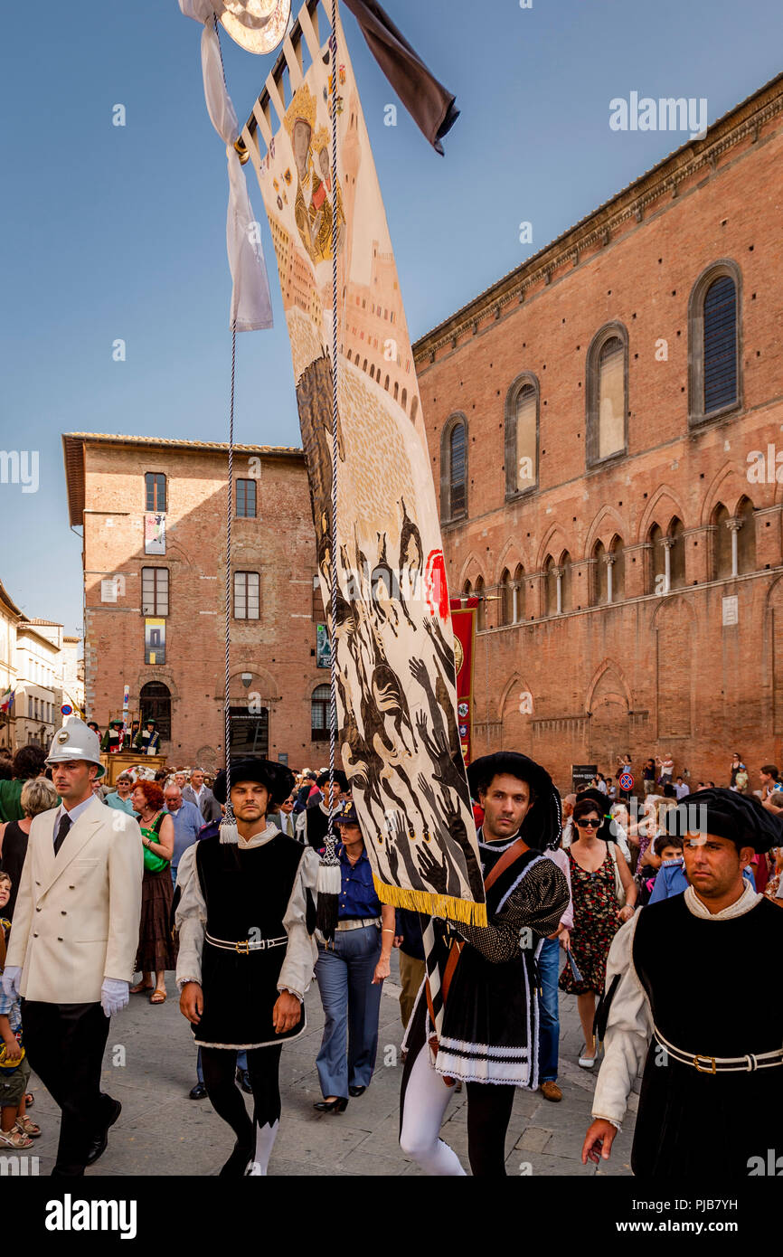 The Palio ‘Banner’ Is Carried Into The Main Cathedral As Part Of The Cero Votivo Procession, The Palio di Siena, Siena, Italy Stock Photo