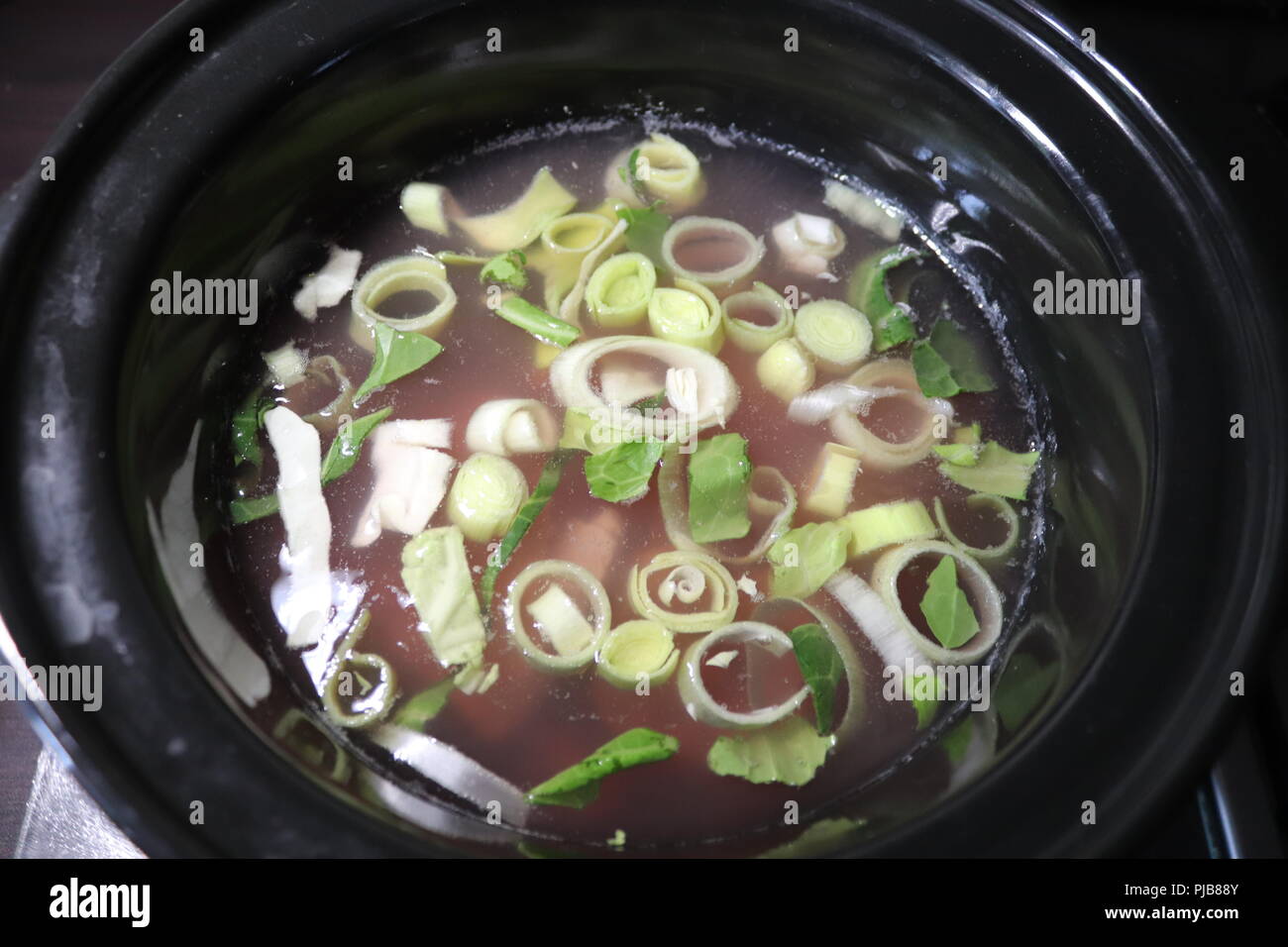 Slow cooker pot of leeks bubbling away Stock Photo Alamy