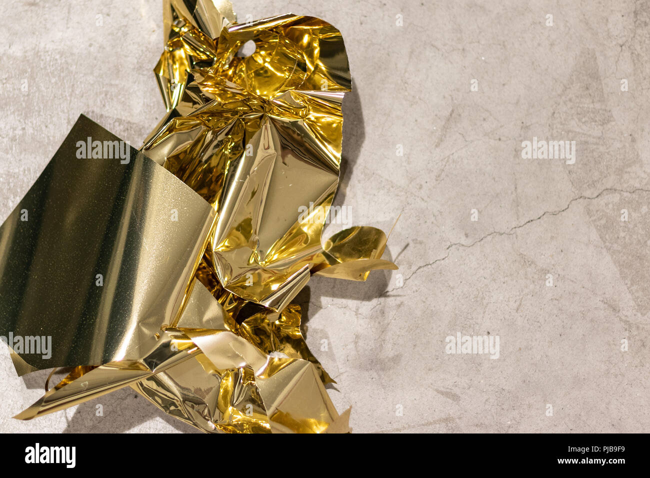 Golden scraps on conrete floor after a massive cutting session for christmas decorations. Stock Photo
