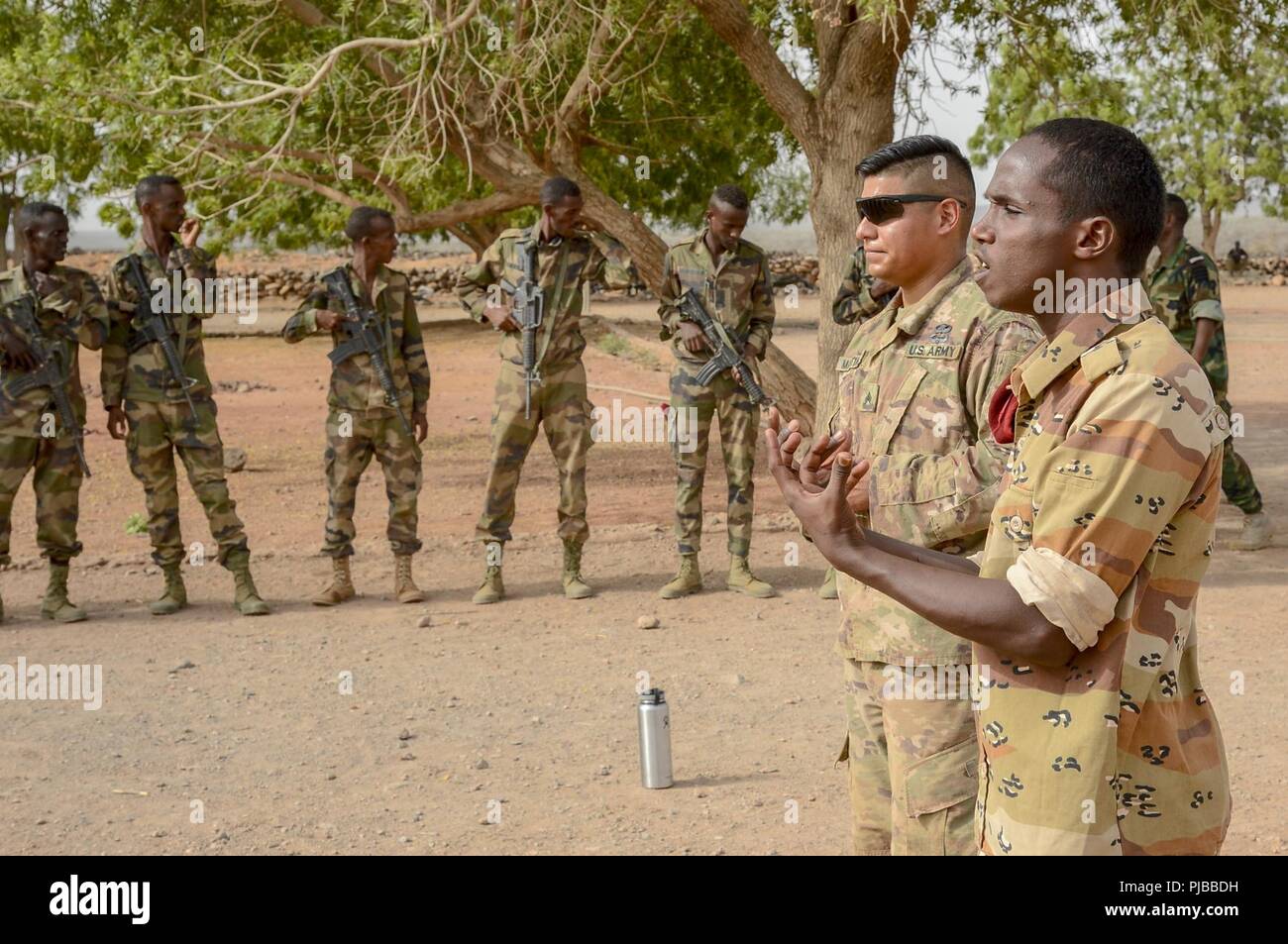 A non-commissioned officer with the Djiboutian Army’s Rapid Intervention Battalion (RIB) and U.S. Army Sergeant Daniel Martinez, Bravo Co., 1st Battalion, 141st Infantry Regiment, Texas National Guard, instruct new recruits at a training site outside Djibouti City, July 3, 2018. The RIB is a U.S. Army trained unit that was formed to respond to crises and promote regional security and stability in East Africa. Stock Photo