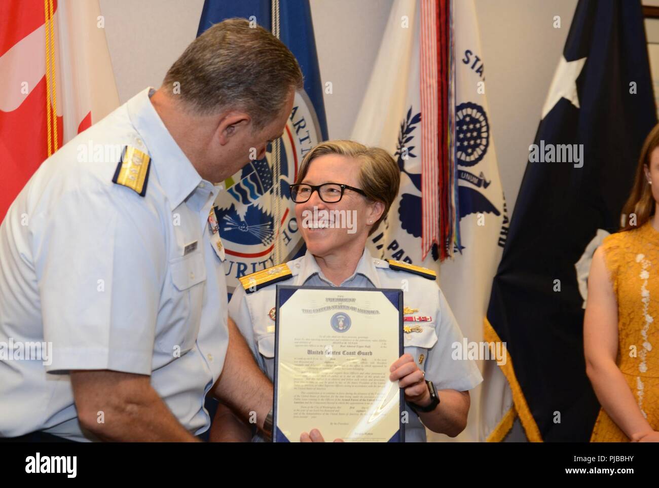 Rear Adm. Joanna Nunan, the Ninth District Commander, smiles as retired Rear Adm. Mike Parks, former Ninth District Commander presents her promotion certificate July 3, 2018 in Cleveland. Nunan was promoted from Rear Adm. Lower Half to Rear Adm. Upper Half. Stock Photo