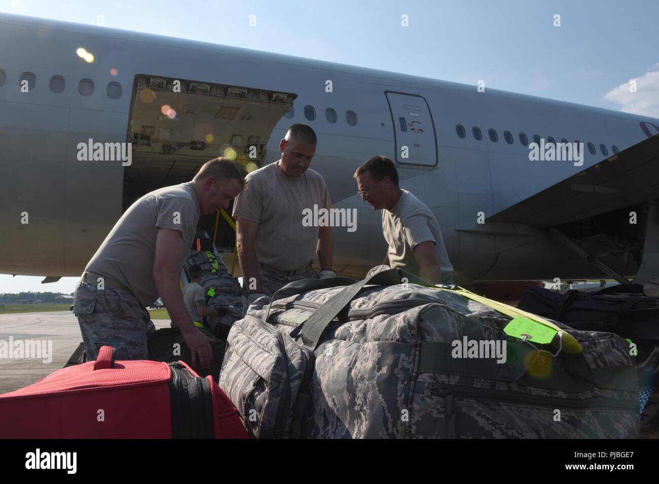 U.S. Airmen of the 169th Fighter Wing of the South Carolina Air National Guard at McEntire Joint National Guard Base, South Carolina, load luggage onto  a civilian-contracted large transport aircraft, July 11, 2018. The South Carolina Air National Guard’s 169th Fighter Wing is deploying nearly 300 Airmen and approximately a dozen F-16 Block 52 Fighting Falcon fighter jets to the 407th Air Expeditionary Group in Southwest Asia in support of an Air Expeditionary Force rotation. Stock Photo